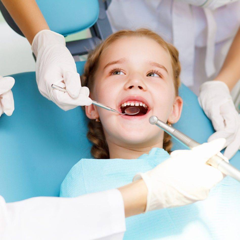 Little girl sitting in the dentists office