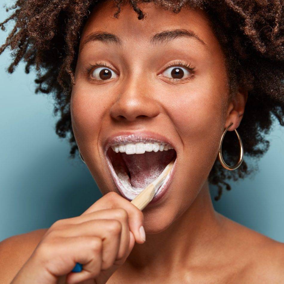 African American female brushing her teeth