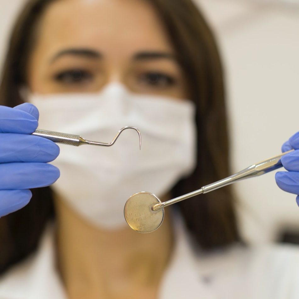 Woman holding up dental tools